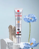 Tube of bbccndc CC cream with blue flowers and a rock on a light gray background